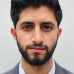 Waseem Akhtar in a suit and tie looks straight to camera.