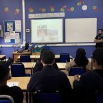 Pupils in a classroom at Sir George Monoux College watch a presentation on the white board.